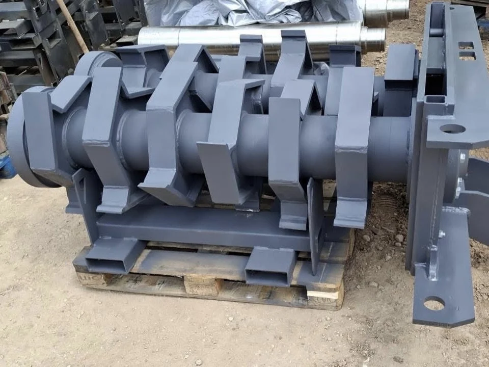 Large industrial shredder shaft and cassette assembly for TEREX CAIMAN 150, resting on a wooden pallet in an industrial setting.