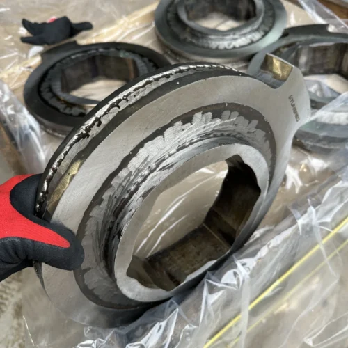 Side view of a refurbished UNTHA RS series cutter disc with visible hardfacing layers before final grinding.