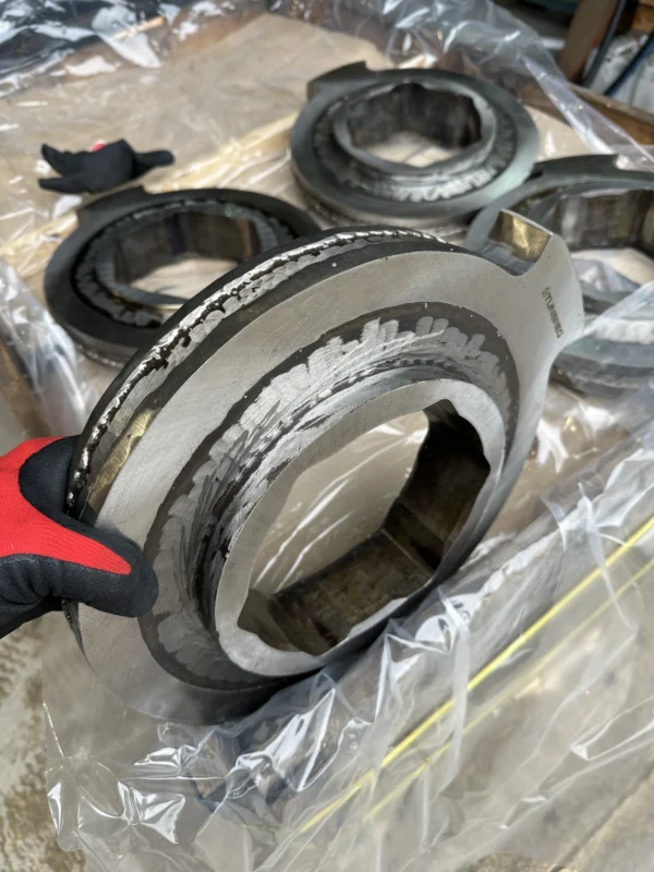 Side view of a refurbished UNTHA RS series cutter disc with visible hardfacing layers before final grinding.