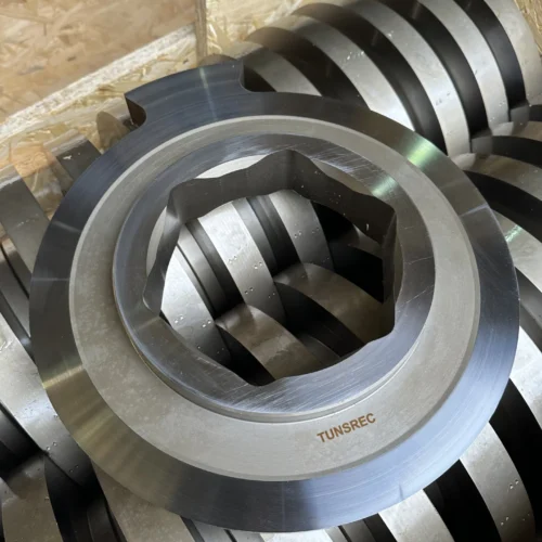 A large quantity of new, shiny, metallic replacement cutter units for UNTHA RS industrial shredders, showcasing their robust construction and readiness for installation.