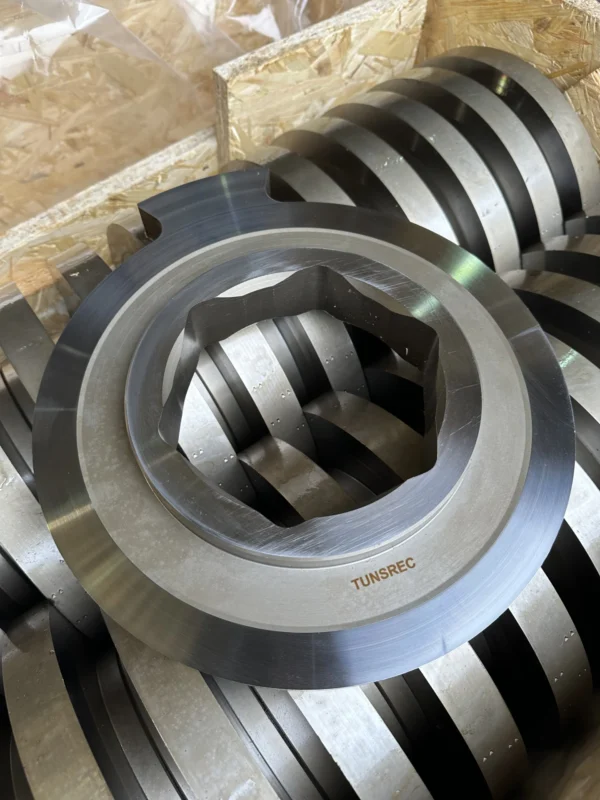 A large quantity of new, shiny, metallic replacement cutter units for UNTHA RS industrial shredders, showcasing their robust construction and readiness for installation.