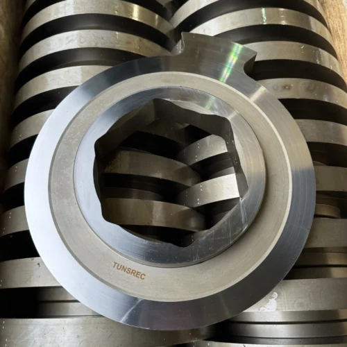 Stack of metallic UNTHA RS shredder cutter units, featuring a prominent TUNSREC part in the foreground, ready for industrial use.