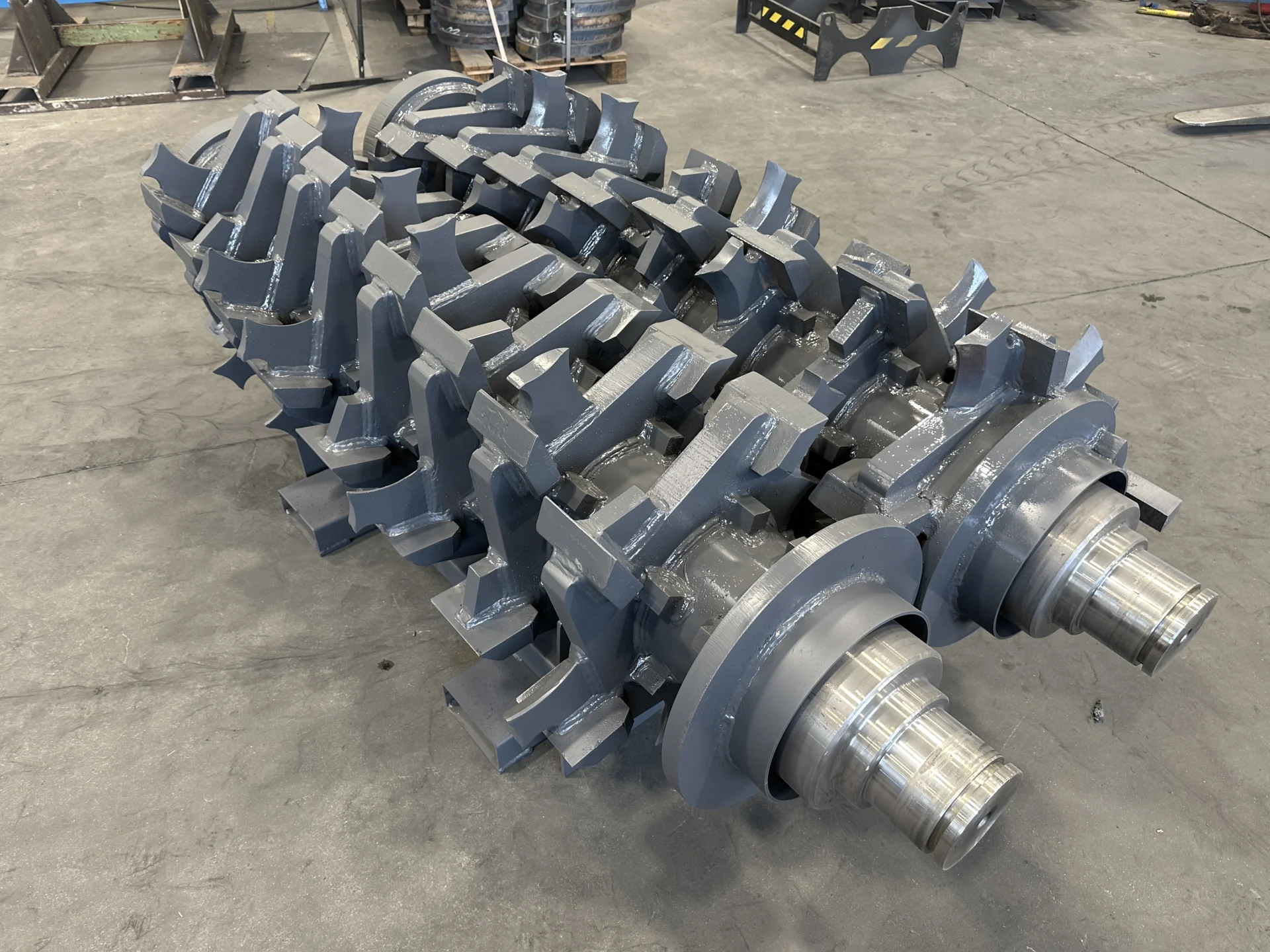 Frontal view of two solid shafts for Pronar 2.85G shredders, showcasing the integrated bearings, multiple discs, and durable knives, ideal for industrial biomass applications.